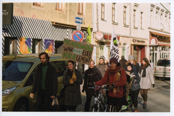 Eine Gruppe von etwa zehn Menschen läuft auf einer Straße in der Dresdener Neustadt. Sie tragen Fahnen der BUNDjugend und ein Plakat, auf dem steht: Mit Abschalten war nicht euer Hirn gemeint.