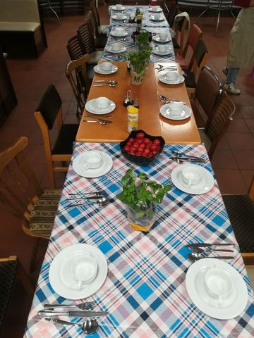 Eine lange, gedeckte Tafel mit karierten Tischdecken.