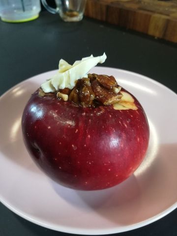 Ein Bratapfel ist auf einem weißen Teller angerichtet.