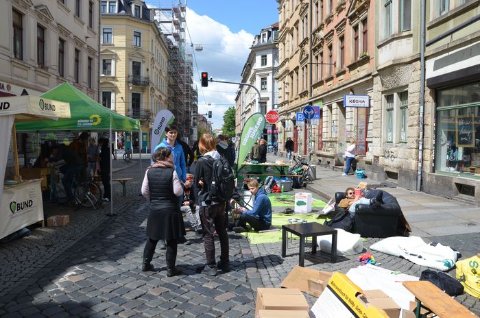 Eine Straße, auf der link Stände des BUND und von Bündnis 90/ Die Grünen stehen, auf der Straße stehen Menschen und unterhalten sich.