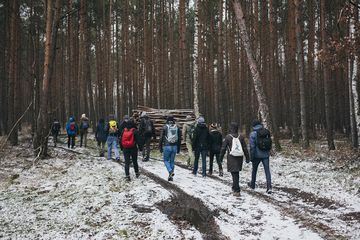 Eine Gruppe äuft über einen Waldweg, der mit einer dünnen Schicht Schnee bedeckt ist.