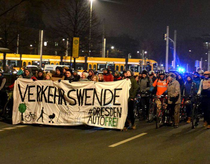 Demozug von vorn bei Nacht. Auf dem Frontbanner steht: Verkehrswende. #Dresden autofrei.