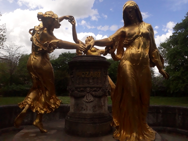 Goldene Figuren auf einem Brunnen.
