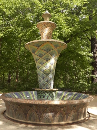 Bunter, mit Fliesen und Mosaiken verzierter Brunnen im Park.